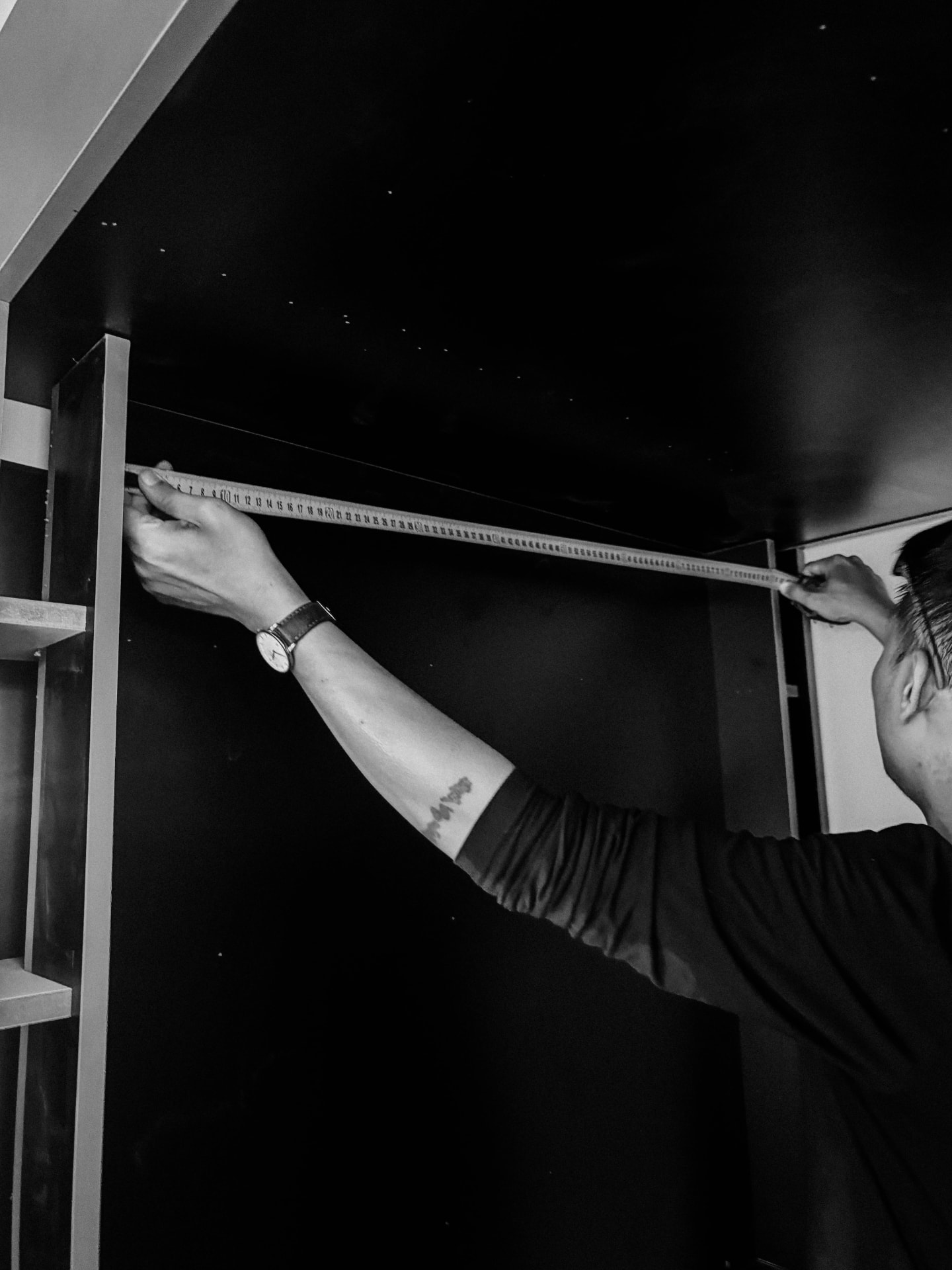 Technician measuring a photobooth frame during a custom build